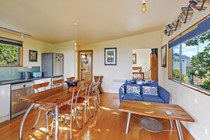 Una cocina moderna con comedor, muebles de madera y un ventanal con vistas.
