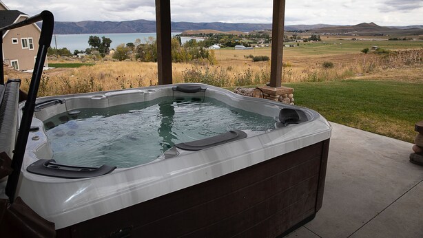 Ein Whirlpool mit Blick auf einen See und Berge.