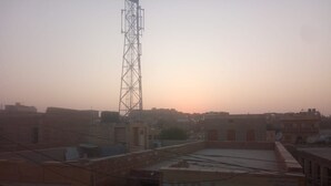A cityscape with a prominent communication tower and buildings with flat roofs. - Aapni Haveli (Jaisalmer)