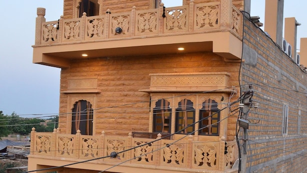 A multi-story building with intricate architectural details, including balconies and ornate window designs. - Aapni Haveli (Jaisalmer)