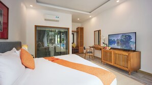 A hotel room with a large bed, a desk with a television, and a view of the outdoors. - Chieu Ha Village (Da Nang)