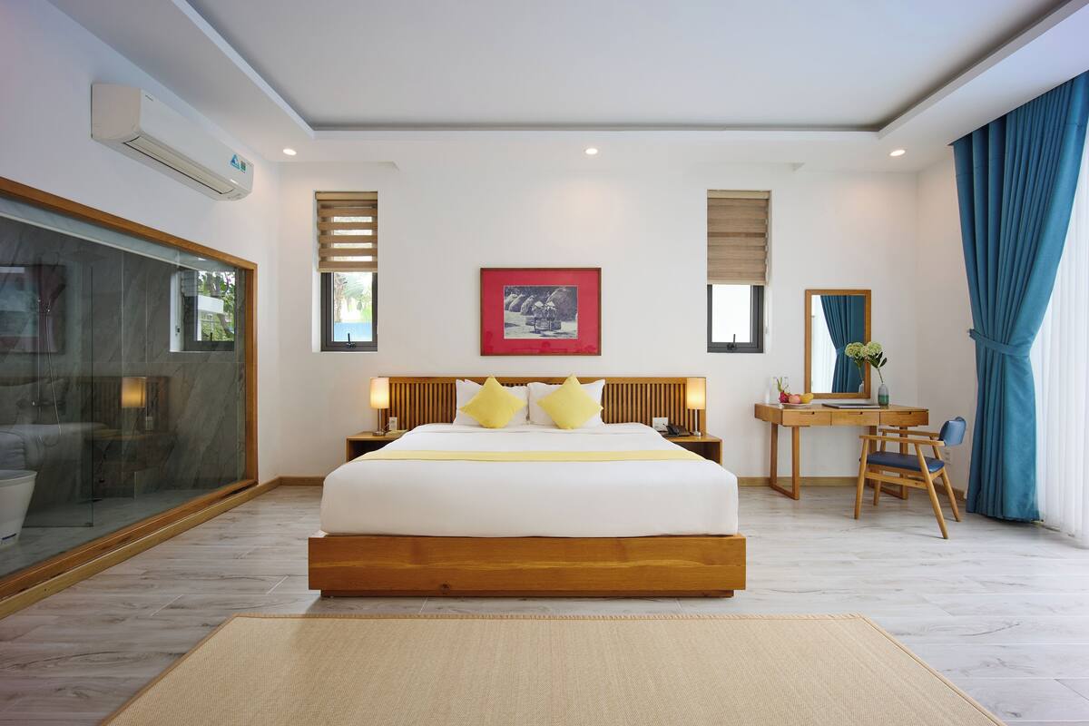 Una habitación de hotel moderna con una cama grande, un escritorio y una silla.