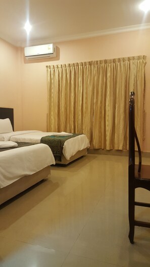 A hotel room with two beds, a chair, a curtain, and an air conditioning unit. - Both Bopha Angkor (Siem Reap)