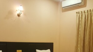 A hotel room with two beds, a headboard, an air conditioning unit, a light fixture, and a curtain. - Both Bopha Angkor (Siem Reap)