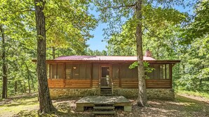 A rustic cabin with a stone foundation, wooden walls, and a metal roof, surrounded by a forest. - Blanchard Cabin in the Woods ~ close to caverns (Mountain View)