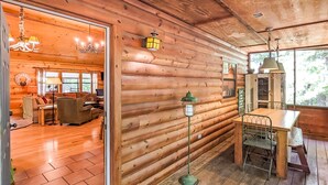 A log cabin interior with a dining area, a living room with a fireplace, and a view of the outdoors. - Blanchard Cabin in the Woods ~ close to caverns (Mountain View)