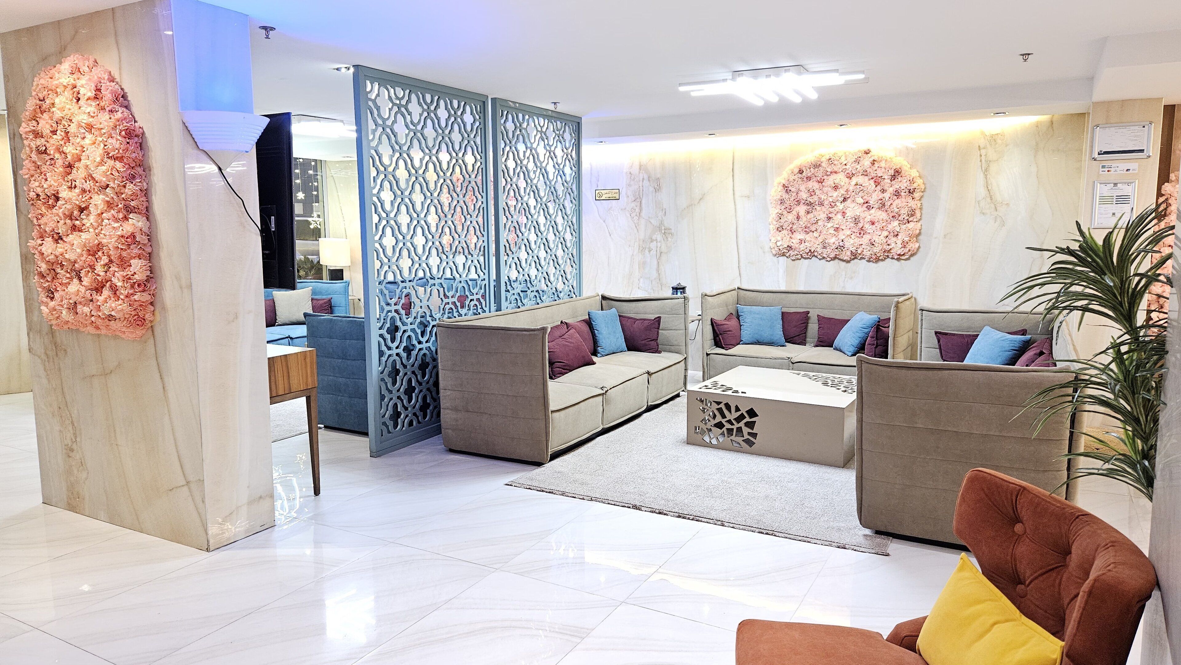 Un espacio de sala moderno con un conjunto de sofás, una mesa de centro y un separador decorativo.