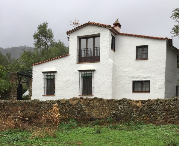 A two-story building with white walls and a stone foundation. - Rural house El Lucero, in the heart of the mountains (full rental) (Alájar)