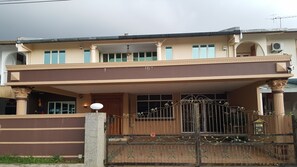 A two-story house with a balcony, a gated entrance, and a decorative iron gate. - Seladah Stay (Kuching)