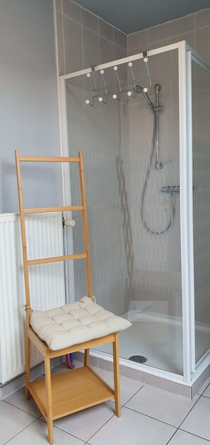 Een bad/douchecombinatie, handdoeken, toiletpapier