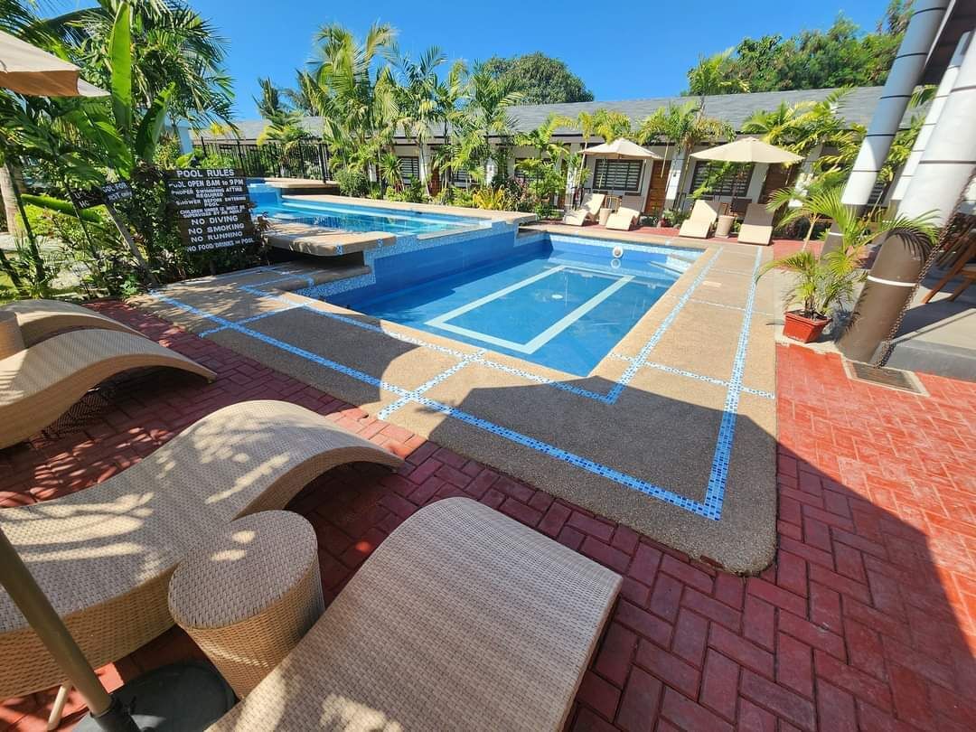 En swimmingpool med liggestole og et skilt, der viser poolregler.