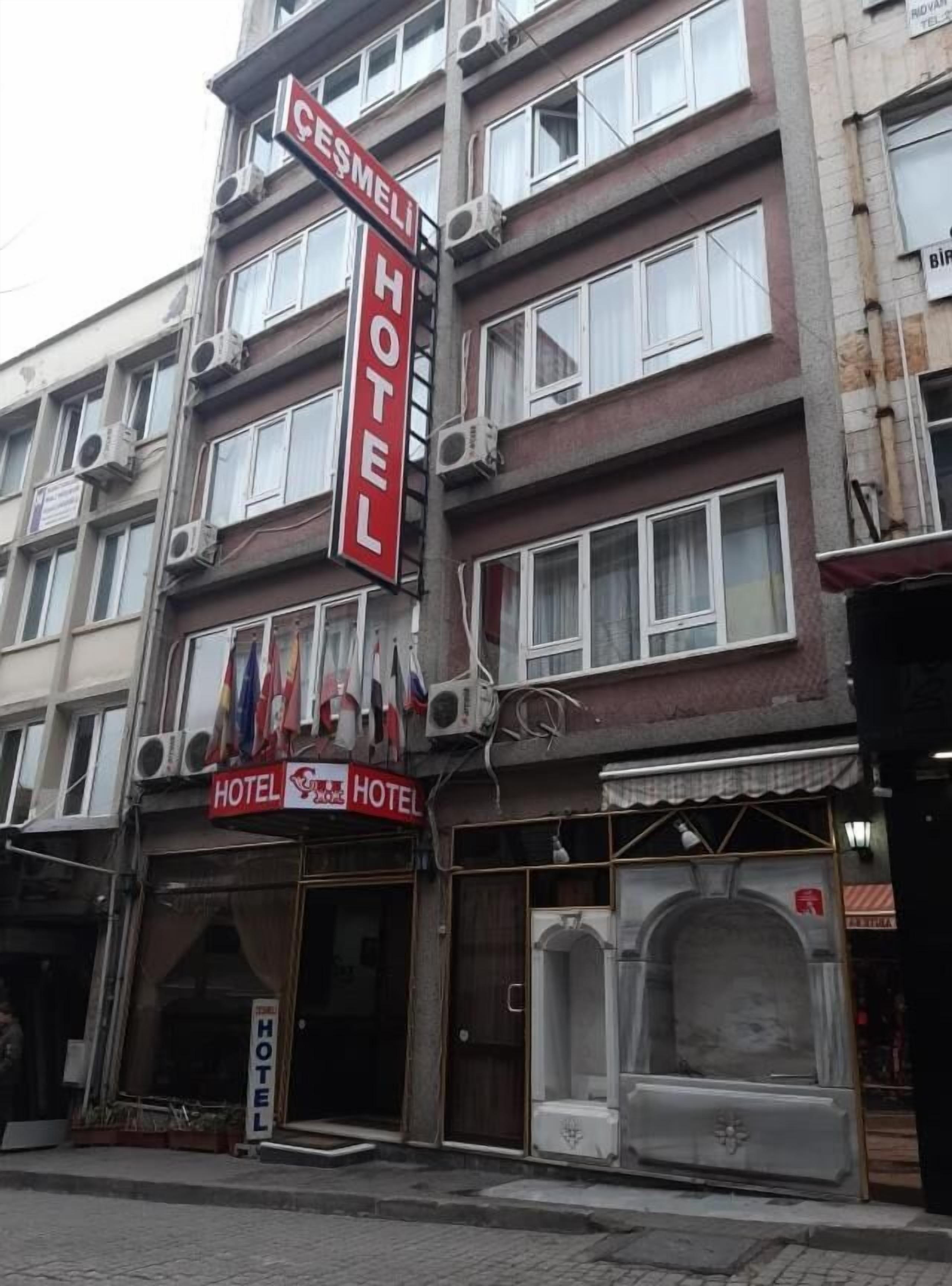 A hotel with a prominent red sign, multiple balconies, and air conditioning units.