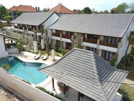 Un resort con varias construcciones, una piscina y zonas de estar al aire libre.