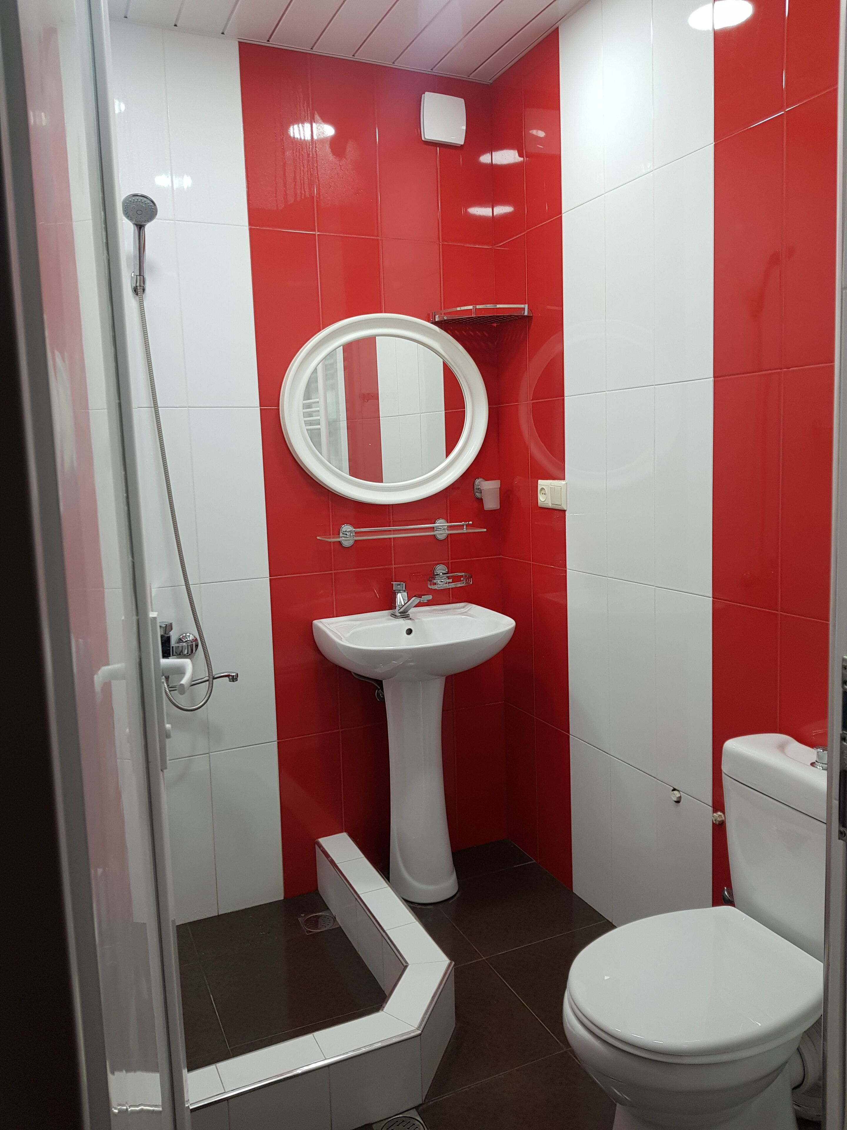 A bathroom with a shower, sink, and toilet.