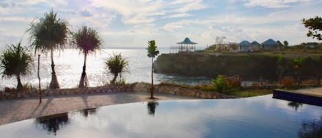 Alberca al aire libre, sombrillas en la alberca y camastros