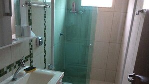 Een badkamer met een wastafel, spiegel en douchecabine.