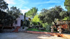 A garden with a stone pathway, a small pond, and a building with a sloped roof. - Independent cottage Val D'amour (Nages-et-Solorgues)