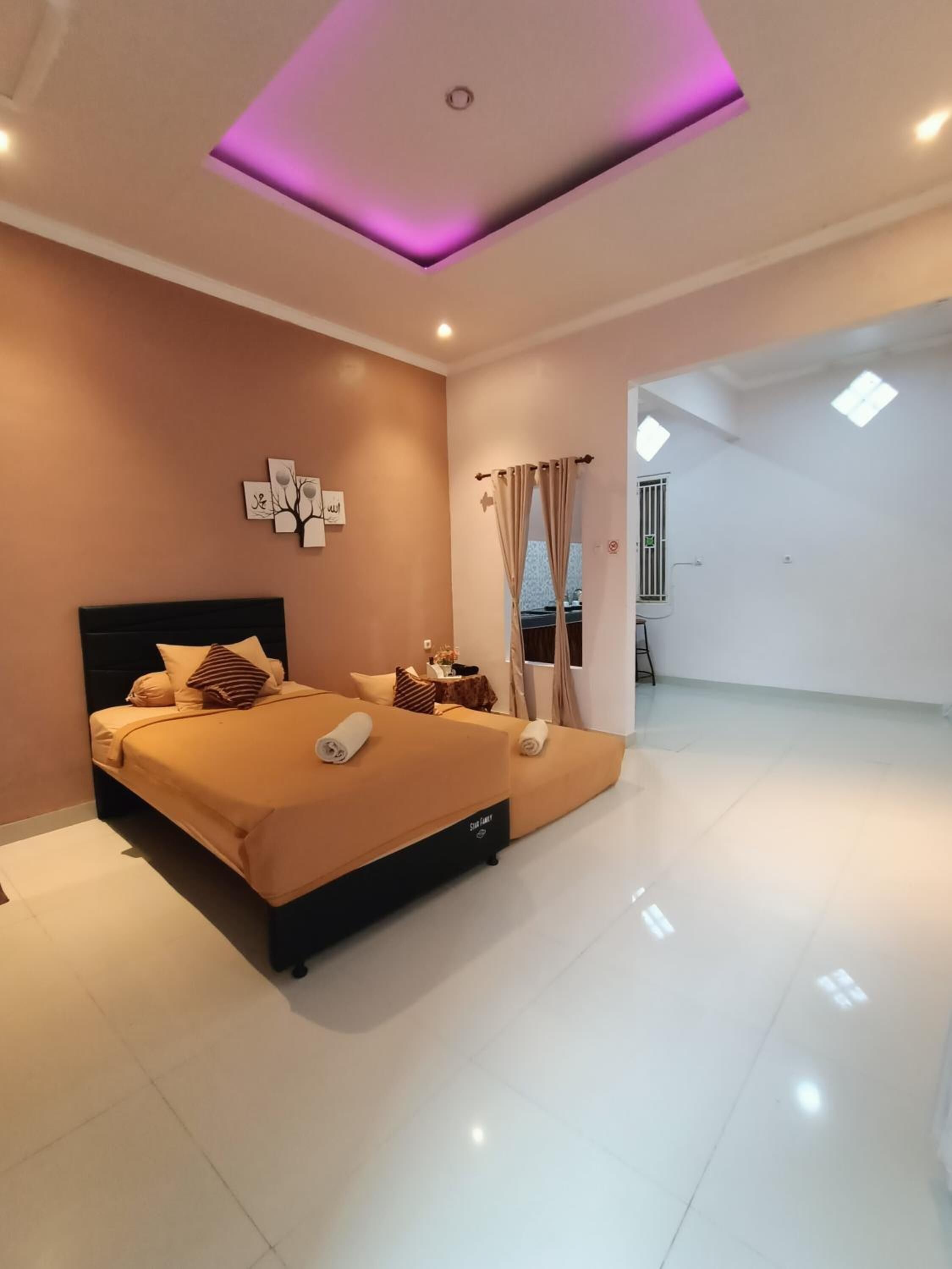 A modern bedroom with a large bed, a ceiling light, and a view of the outdoors.