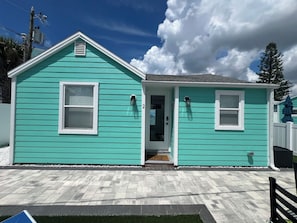 A two-story house with a front door, a mailbox, and a small porch area. - Bay Breeze - Cozy Beach Cottage across from the beach. Pet friendly! (Madeira Beach)