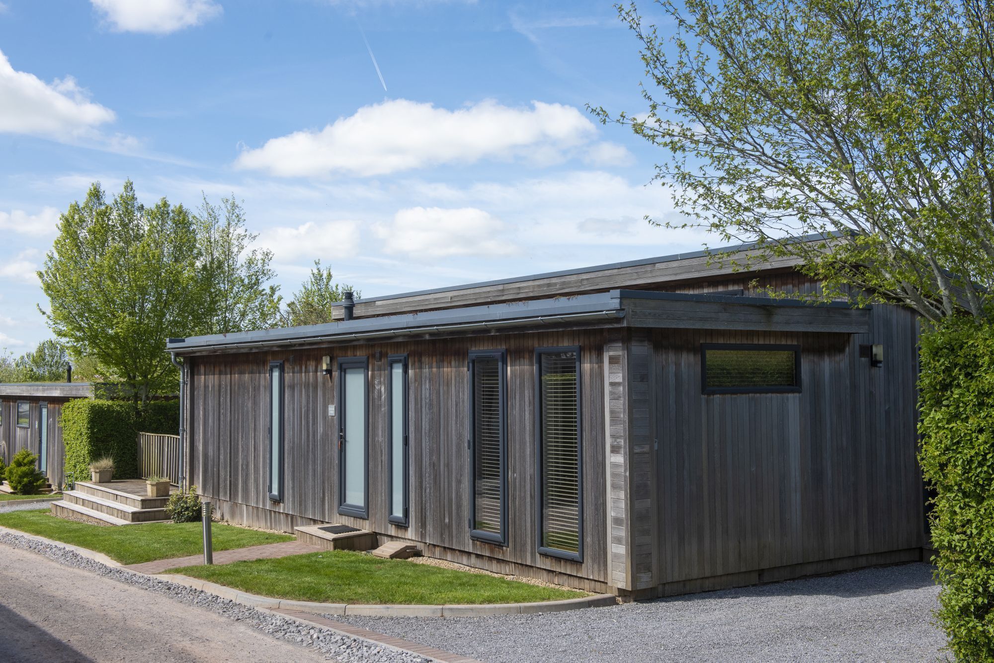 A modern wooden building with large windows and a flat roof.