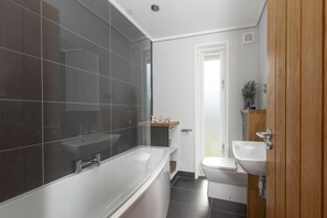 A modern bathroom with a bathtub, a sink, and a toilet. - Diamond Lodge - Hot Tub - Free WiFi & Parking - Pets Welcome (Cheddar)