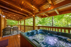 Relax on the elevated deck with a hot tub and outdoor seating area.