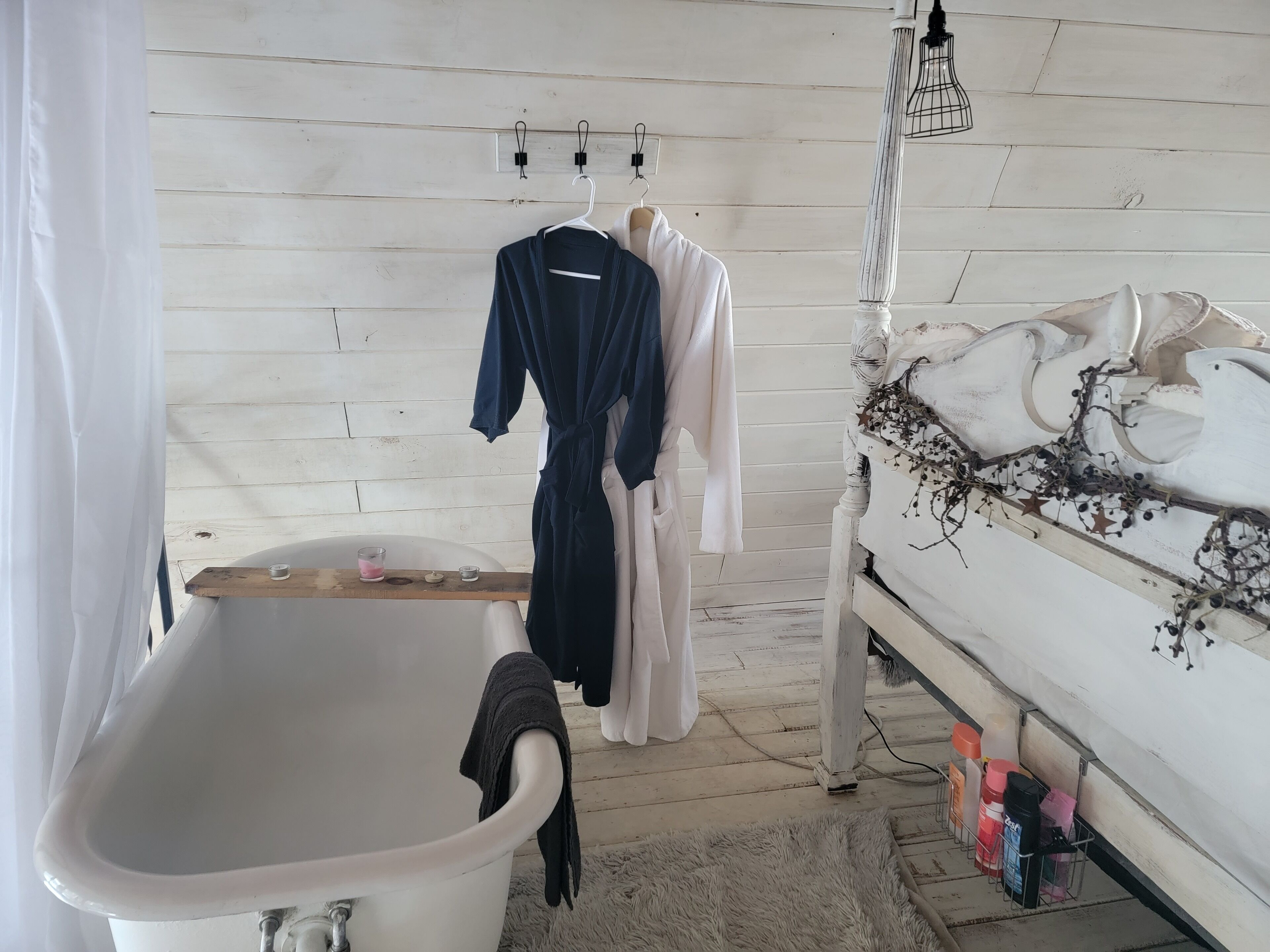 A bathroom with a bathtub, a white sink, and a vanity with toiletries.