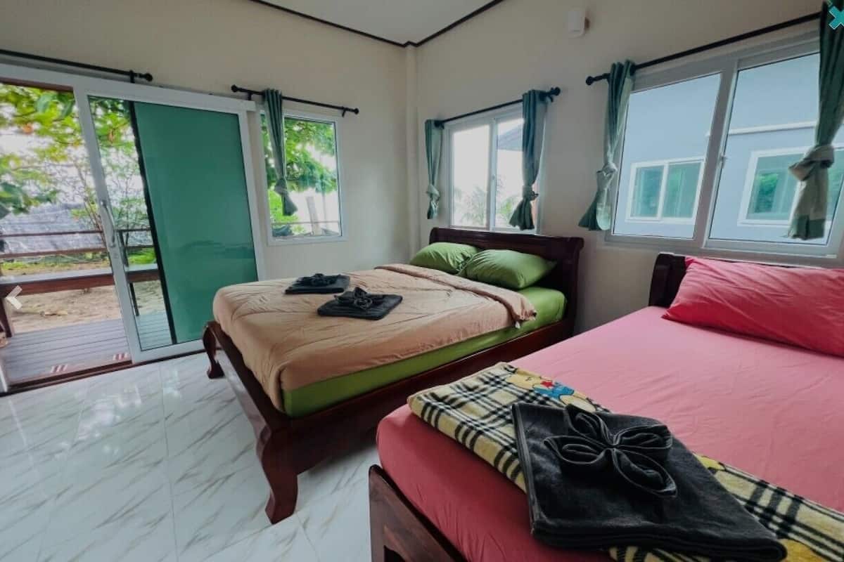 A bedroom with a bed, a bench, and a window.