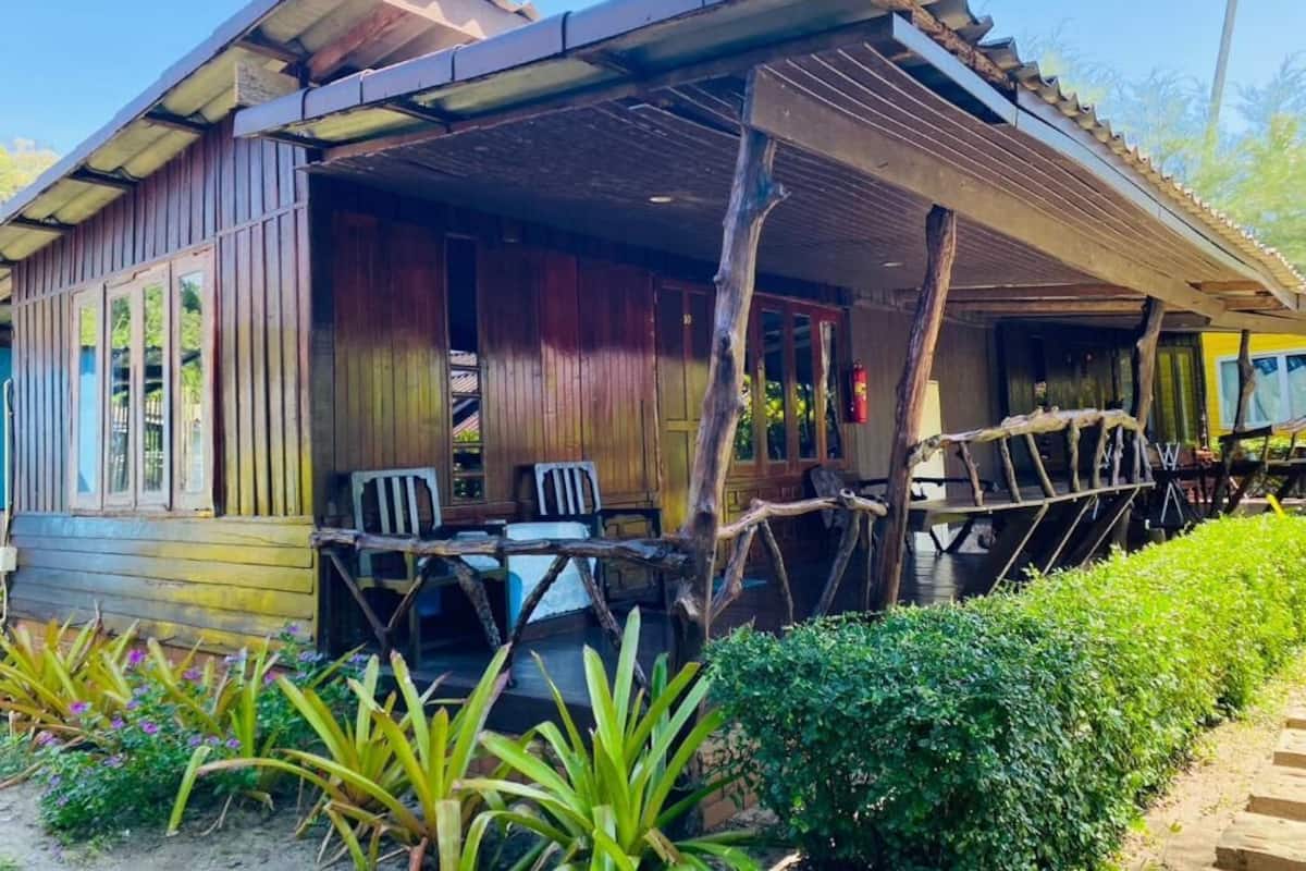 A rustic wooden building with a covered porch and outdoor seating area.