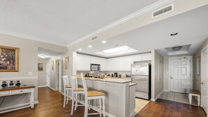 A spacious kitchen with a central island, white cabinetry, and a dining area with a bench.