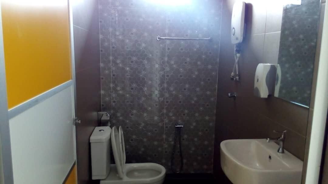 A bathroom with a toilet, a sink, and a shower stall.