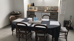 Ein Essbereich mit einem runden Tisch, vier Stühlen und einer Schale mit Wasserflaschen und Snacks.