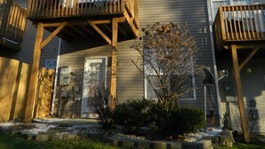 A multi-story residential building with a wooden deck and a small garden area in front. - Cozy and Convenient Furnished Townhome w/view (High Point)