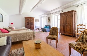 Uma sala de estar ampla com sofá, cadeiras, mesa de centro e um grande armário de madeira.