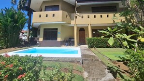 Un edificio de dos pisos con una piscina delantera.