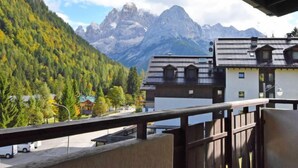 Une vue sur la montagne avec un bâtiment doté d’un balcon.
