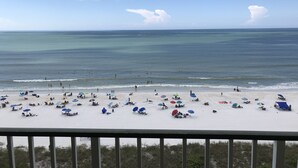 A beach with umbrellas and people, a clear sky, and the ocean. - Apollo 9th floor private beachfront balcony  **Majestic Views* (Marco Island)
