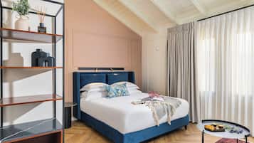 Un dormitorio con cama, una mesita de noche, una estantería y una ventana con cortinas.