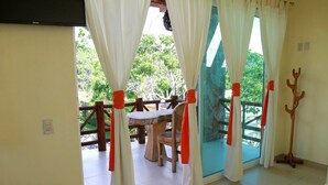 A room with a sliding glass door leading to an outdoor area with a wooden table and chairs. - VILLAS DULCE SUEÑOS (Rincón de Guayabitos)