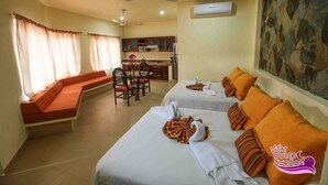 A hotel room with two beds, a dining area, and a kitchen. - VILLAS DULCE SUEÑOS (Rincón de Guayabitos)