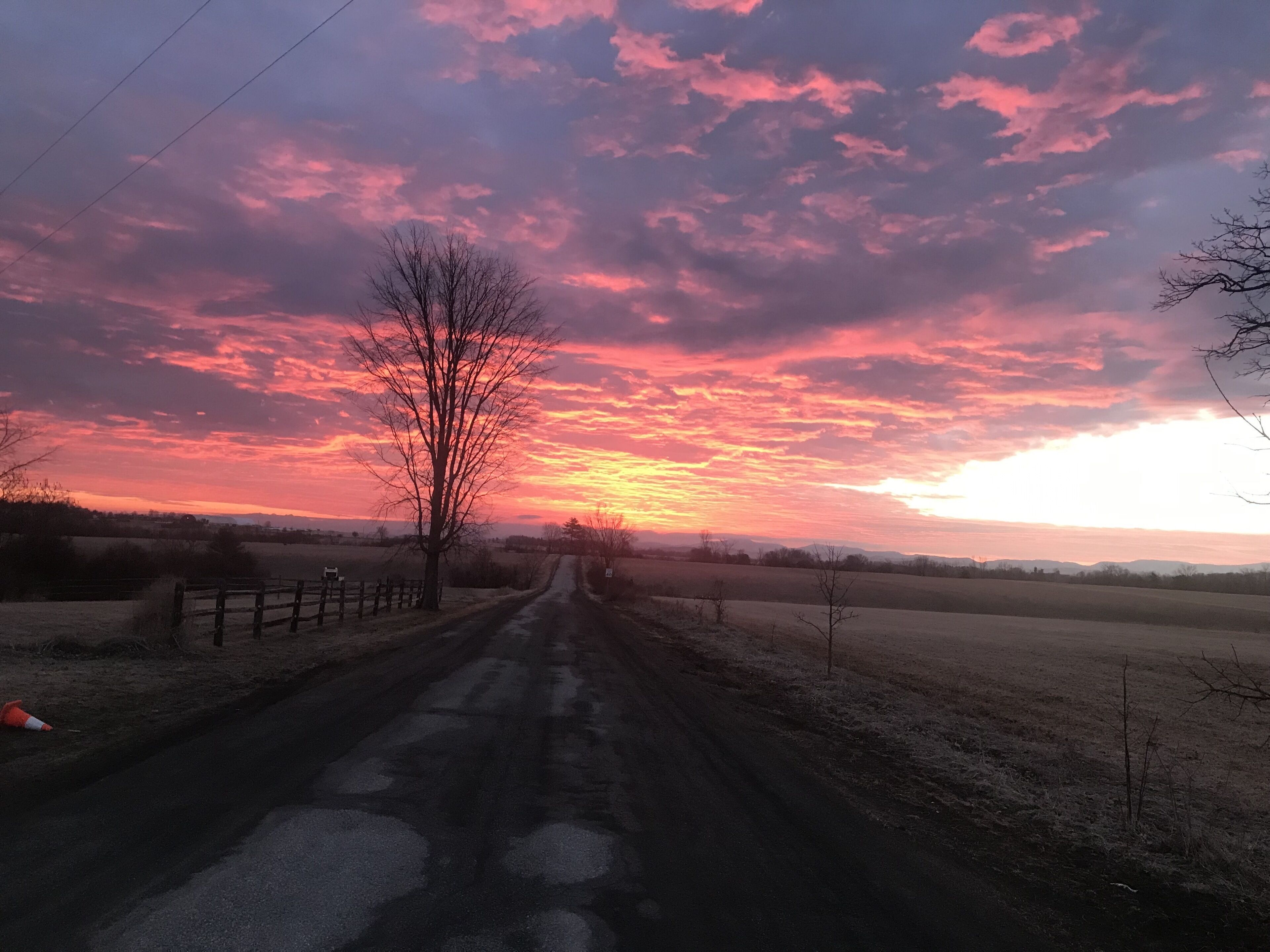 A rural road with a sunset sky.
