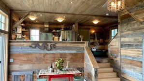 A rustic wooden interior with a dining area, staircase, and kitchen. - Remodeled Barn in Champlain Valley, Essex, NY (Essex)