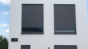 A modern building with three large windows and two smaller ones, a flat roof, and a sign indicating the address "34cl". - Kruft-apps (Kruft)