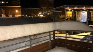 Un espacio exterior cubierto de nieve con una escalera de madera y barandilla de metal.