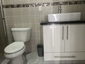 A bathroom with a toilet, a sink, and cabinets. - Suitable. Strategic (attached to the Sentri and the Airport) (Tijuana)