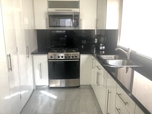 Fridge, microwave, coffee/tea maker, cookware/dishes/utensils