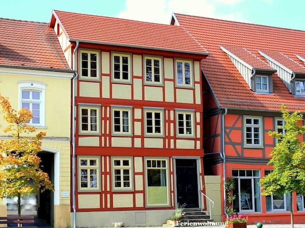 A traditional half-timbered building with a red roof, multiple windows, and a visible entrance.