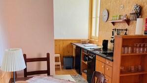 Une cuisine avec des meubles de rangement en bois, une cuisinière, un évier et une table à manger avec des chaises.