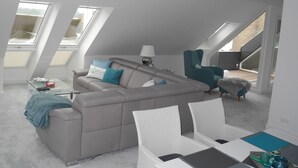 Un appartement moderne de style « loft » avec un canapé d’angle gris, des coussins d’accent turquoise, une table basse en verre et un fauteuil turquoise.