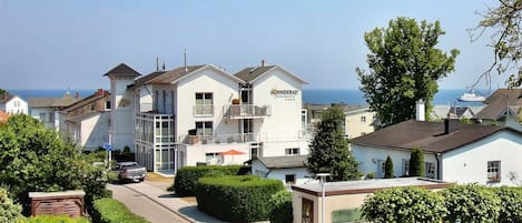 A white building with balconies and a sign reading "Sonnenbad".